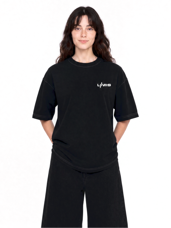 T-shirt Essence Tee LUMIS noir porté par une femme, vue de face : logo brodé sur la poitrine, coupe oversize